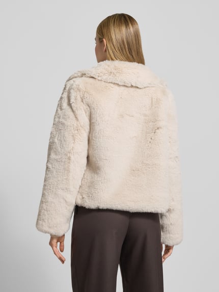 Vrouwenmodel draagt Jacke aus Kunstfell mit Eingrifftaschen van Milano Italy in beige, regular fit, met omgeslagen kraag, zijzakken, ruglengte 55 cm, schouderbreedte 42 cm, borstwijdte 53 cm, mouwlengte 63 cm, Ganzkörperaanzicht achteraan.