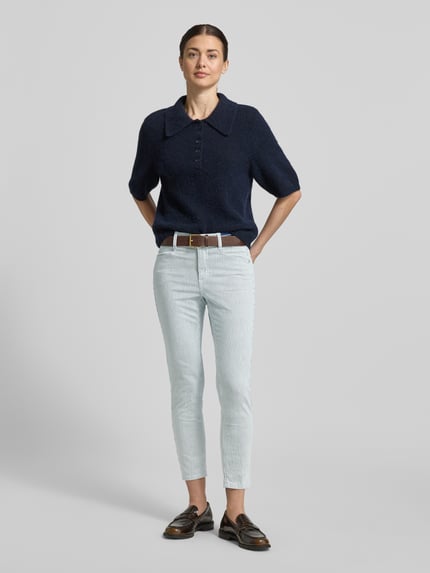 Frauenmodel trägt Slim Fit Jeans mit elastischem Bund Modell 'Ornella' von Angels, heller Baumwoll-Mix, Eingriff- und Gesäßtaschen, Ganzkörperansicht von vorne.