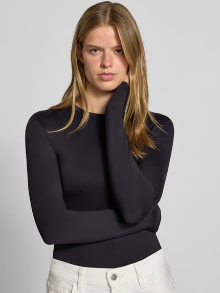 Frauenmodel trägt schwarzes Slim Fit Langarmshirt mit Rundhals-Ausschnitt Modell 'LULA' von PIECES, Damen Langarmshirt, Nahaufnahme Oberkörper
