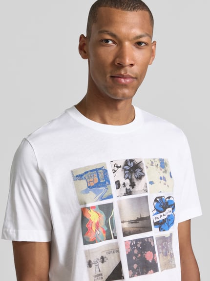 Männermodel trägt weißes T-Shirt mit Fotoprints von Paul Smith, reine Baumwolle, Regular Fit, Rundhalsausschnitt, Nahaufnahme Oberkörper.
