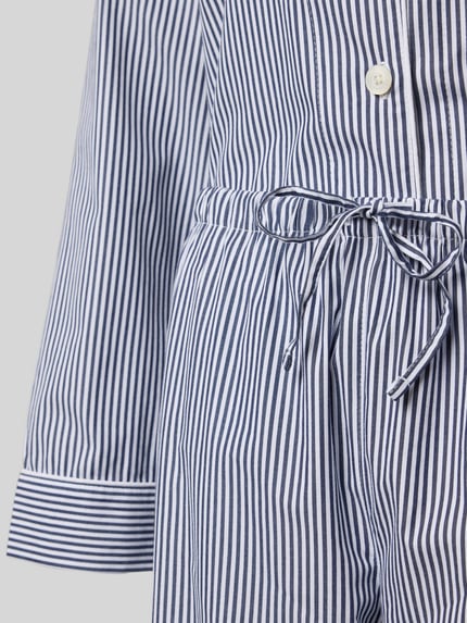 Vrouwenmodel draagt Pyjama met borstzak van Lauren Ralph Lauren in blauw-wit gestreept katoen, detailopname middelste deel.