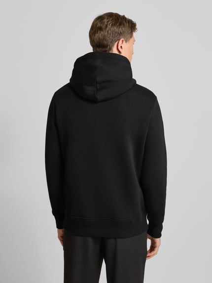 Männermodel trägt Hoodie mit Label-Stitching und Känguru-Tasche von Gant, schwarz, Baumwoll-Mix, Regular Fit, Ganzkörperansicht Rückansicht