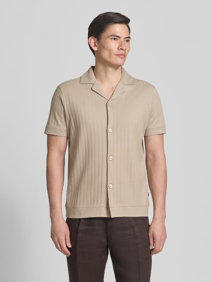 Männermodel trägt Regular Fit Poloshirt mit durchgehender Knopfleiste von JOOP! Collection, reine Baumwolle, Ganzkörperansicht von vorne.