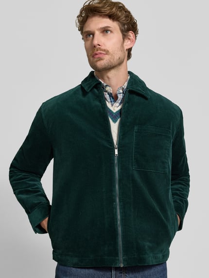 Männermodel trägt Regular Fit Hemdjacke aus Cord mit Brusttasche von MCNEAL in Dunkelgrün, Baumwoll-Elasthan-Mix, Nahaufnahme Oberkörper
