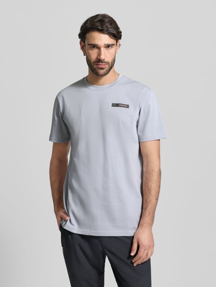 Männermodel trägt Regular Fit T-Shirt mit Logo-Applikation von Under Armour in Hellgrau, Baumwoll-Mix, Rundhalsausschnitt, Nahaufnahme Oberkörper.