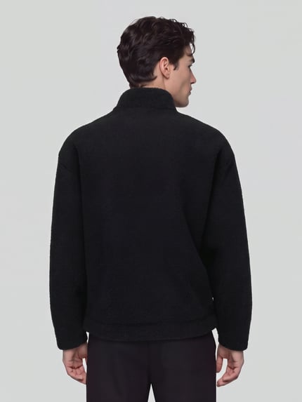 Männermodel trägt Sweatshirt mit Logo-Detail Modell 'Derylong' von HUGO in Schwarz, Fleece-Struktur, Ganzkörperansicht Rückansicht.