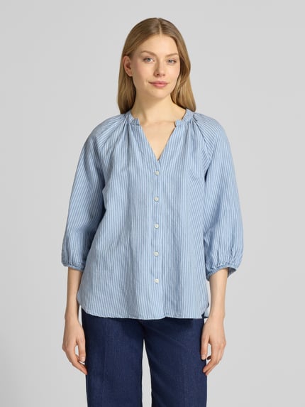 Vrouwenmodel draagt Relaxed Fit overhemdblouse Leinen-Baumwoll-Mix model 'ALBERTA' van Selected Femme, gestreept, meerkleurig, mix van linnen en katoen, V-hals, knoopsluiting, 3/4-mouwen met raglanmouwen, elastische zoom, rompzoom afgerond, voorkant volledig zichtbaar, overwegend blauwe tinten, ganzebodyaanzicht van voren.