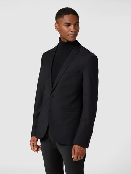 Männermodel draagt Regular Fit Sakko mit Woll-Anteil Modell 'Irving' van Drykorn, elastische materiaalmix, reverskraag, 2-knoopsluiting, paspelzakken, borstzak, zwart, glad oppervlak, ganzkörperansicht van voren.