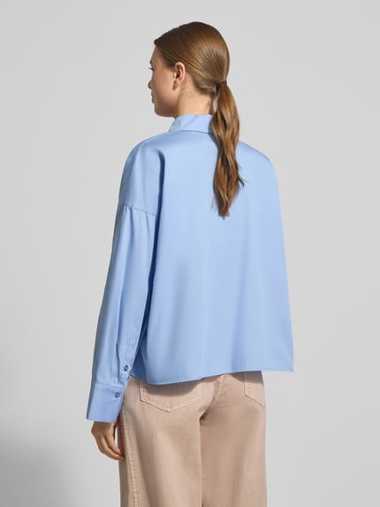 Frauenmodel trägt Hemdbluse mit verdeckter Knopfleiste Modell 'Fundra' von OPUS aus reiner Baumwolle, lockerer Schnitt, Ganzkörperansicht Rückansicht.