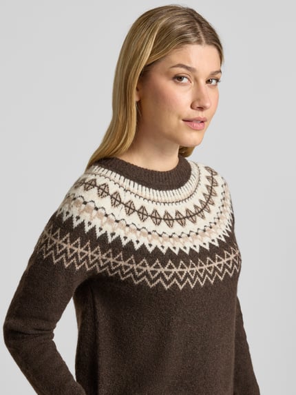 Frauenmodel trägt Pullover mit kontrastreichem Rundhals-Strickmuster von VERO MODA, mehrfarbig, florales und geometrisches Jacquardmuster, Nahaufnahme Oberkörper.