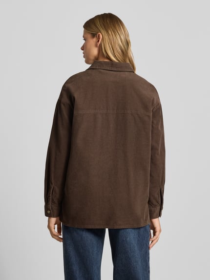 Frauenmodel trägt Relaxed Fit Hemdjacke aus reiner Baumwolle Modell 'MOXIE' von ONLY in Braun, strukturierte Oberfläche, Damen Hemdjacke, Ganzkörperansicht Rückansicht.