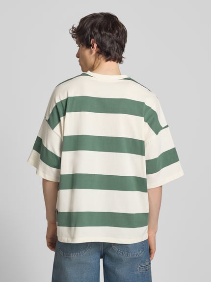 Männermodel trägt T-Shirt mit Streifenmuster Modell 'KAVEH' von Blend, grün-weiß, Baumwolle, Relaxed Fit, Ganzkörperansicht Rückansicht
