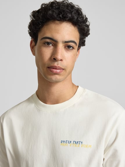 Männermodel trägt Relaxed Fit T-Shirt aus reiner Baumwolle mit Motiv-Print von Marc O’Polo Denim, unifarben, Nahaufnahme Oberkörper.