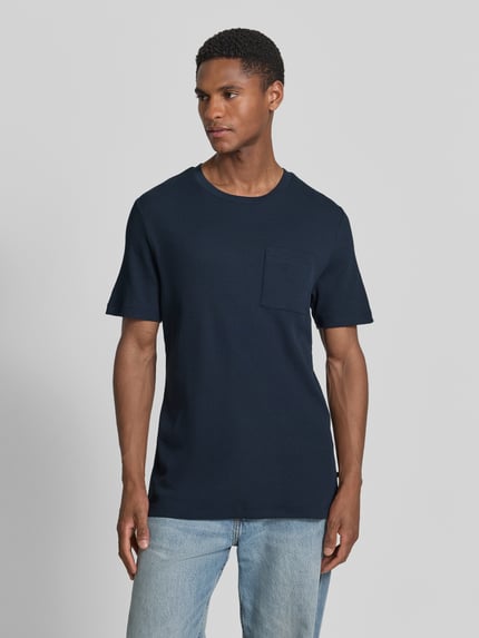 Männermodel trägt Regular Fit T-shirt aus katoenmix van s.Oliver RED LABEL, look: effen, gestructureerd, met borstzak, piqué, korte mouw, ronde hals, ganzkörperansicht van voren.
