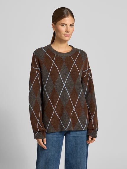 Vrouwenmodel draagt Strickpullover im Allover-Look Modell 'argyle' van VILA, relaxed fit, gemêleerd bruin en grijs, ronde hals, voorkant full body shot, materiaal-mix met stretch, ruglengte 62 cm, mouwlengte 49 cm.