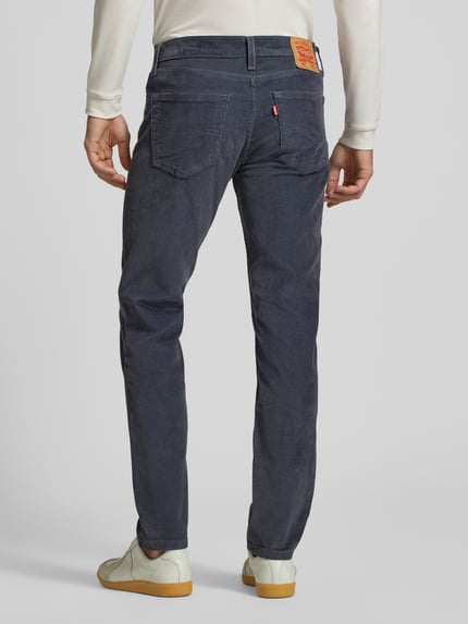 Männermodel trägt dunkelblaue Slim Fit Jeans aus Baumwoll-Mix Modell '511® SLIM' von Levi's®, Herren Jeans, Ganzkörperansicht Rückansicht.