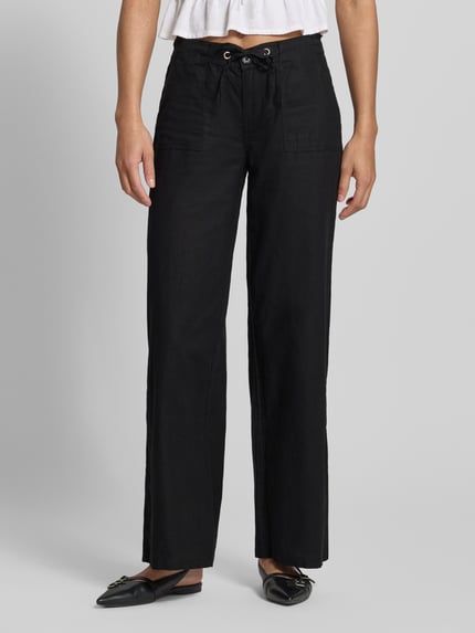 Kobiece modelka nosi Mid Waist spodnie z mieszanki lnu i bawełny od Gina Tricot, czarne, szerokie nogawki, wpuszczane kieszenie, tunel, szerokość w rozmiarze 36: 40 cm, długość wewnętrzna nogawki w rozmiarze 36: 78 cm, widok całej sylwetki z przodu