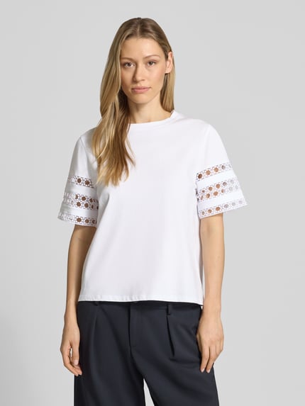 Vrouwenmodel draagt wit T-shirt met 1/2-mouwen, puur katoen, getailleerd, ronde hals, met kant, model 'APE' van EMME, ruglengte maat S 56 cm, vooraanzicht bustenahaufnahme.
