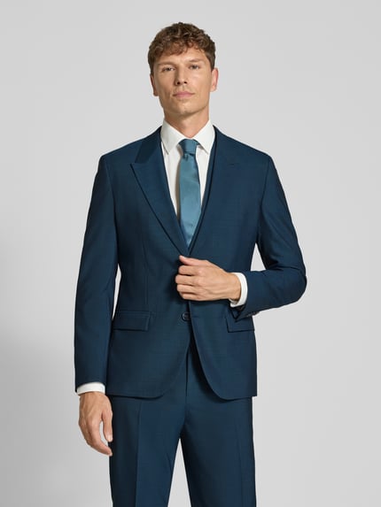 Männermodel trägt Regular Fit Anzug aus Wolle mit Bundfalte von HUGO in Dunkelblau, feines Webstruktur, Reverskragen, Nahaufnahme Oberkörper.