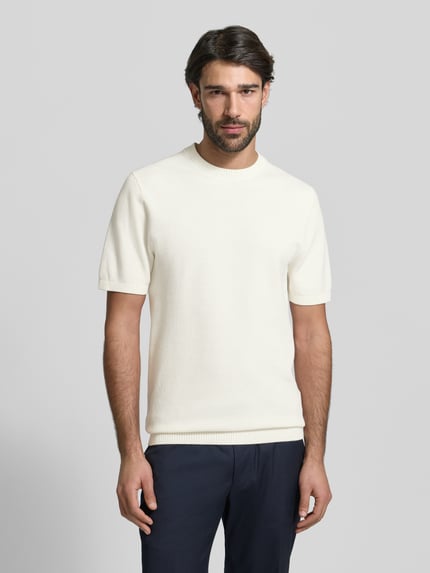 Męskimodel prezentuje Regular Fit T-Shirt aus reiner Baumwolle von MCNEAL, prążkowana stójka, prążkowane wykończenia, fakturowany wzór, długość tyłu w rozmiarze M: 71 cm, długość rękawów w rozmiarze M: 27 cm, jasny kolor, gładka tekstura, fakturowana powierzchnia, całkowity widok z przodu.