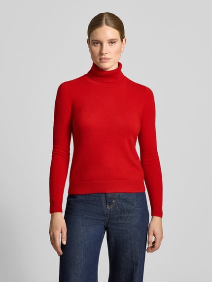 Frauenmodel trägt Regular Fit Rollkragenpullover aus reinem Kaschmir von Christian Berg Woman in Rot, gerippte Abschlüsse, Ganzkörperansicht von vorne.