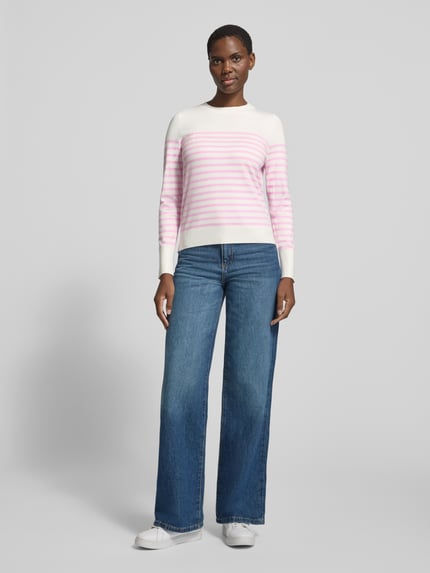 Frauenmodel trägt Pullover mit gerippten Abschlüssen von S.OLIVER CASUAL in Strickoptik, gestreift in Weiß und Rosa, Regular Fit, Ganzkörperansicht von vorne.