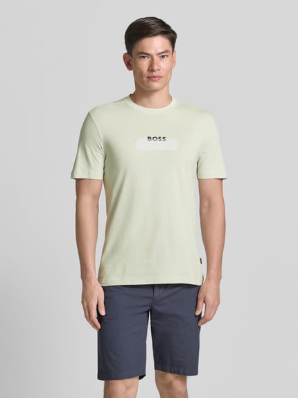 Männermodel trägt Regular Fit T-Shirt aus reiner Baumwolle Modell 'Te_LOGOTAPE' von BOSS Orange, unifarben, Rundhals, Label-Schriftzug, Ganzkörperansicht von vorne