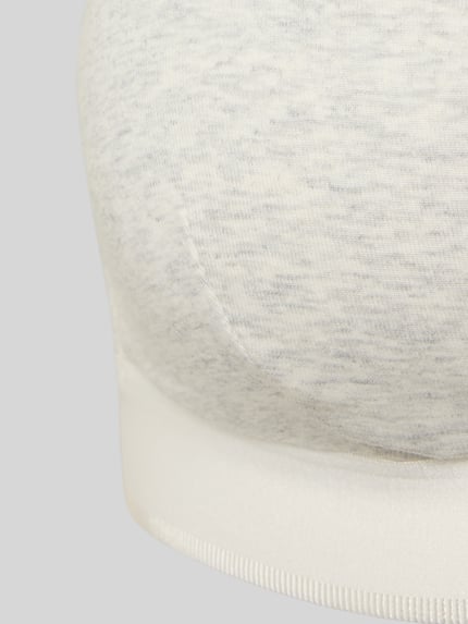 Frauenmodel trägt Bralette in Triangel-Form mit verstellbaren Trägern von PUMA aus Baumwoll-Elasthan-Mix, körpernahe Passform, Detailaufnahme.