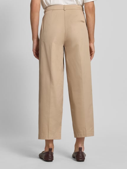 Frauenmodel trägt Hose mit Falten und Gesäßtasche von Rich & Royal aus Baumwoll-Elasthan-Mix in Beige, Wide Leg, Ganzkörperansicht Rückansicht.