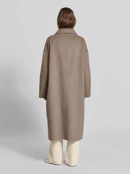 Frauenmodel trägt Wollmantel aus Woll-Mix von MYON in Beige, lockere Passform, Rückansicht, Ganzkörperansicht Rückansicht.