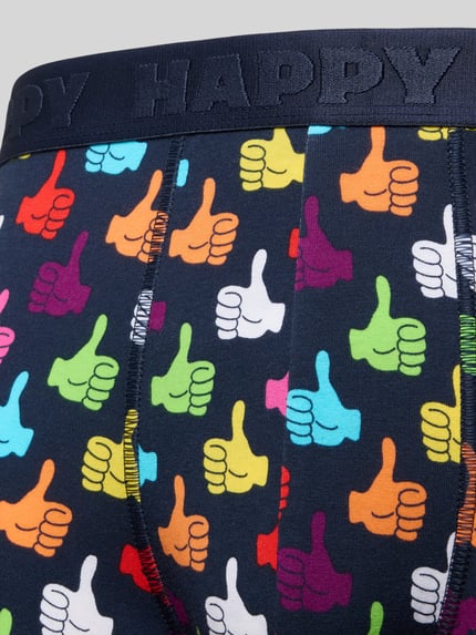 Männermodel draagt Boxershorts mit elastischem Logo-Bund im 3er-Pack van Happy Socks, kleurrijk duimenpatroon, katoenen stretch, Nahaufnahme Oberkörper.