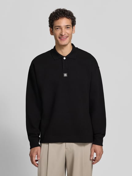Męski model nosi czarną bluzę z mieszanki bawełny Oversize Fit Sweatshirt aus Baumwoll-Mix model 'Dabins' od HUGO, Ganzkörperansicht von vorne. Bluza męska HUGO