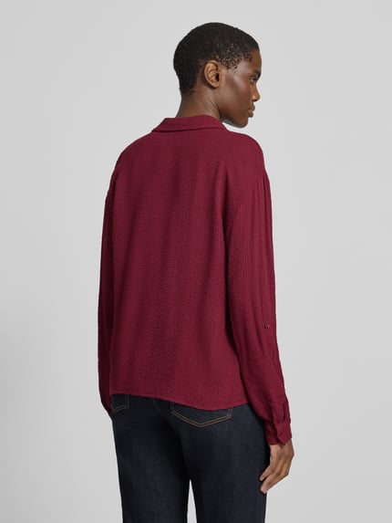Frauenmodel trägt Hemdbluse mit strukturierter Crinkle-Optik aus Viskosemix von Tom Tailor in Unifarbe, langarm, Rückansicht.