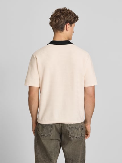 Männermodel trägt Regular Fit Poloshirt mit V-Ausschnitt Modell 'COTEDAZUR' von Jack & Jones, Reine Baumwolle, Rückenlänge 67 cm, Ganzkörperansicht Rückansicht.