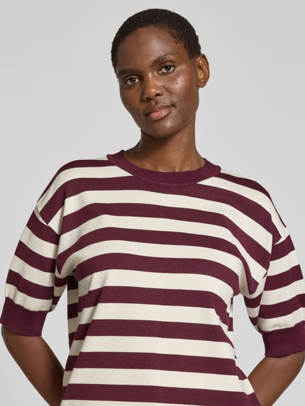 Vrouwenmodel draagt Relaxed Fit Strickpullover aus Viskose-Mix Modell 'morla' van b.young, korte mouw, streepmotief, viskeusmix, bordeauxrood en crème, bovenlichaam close-up.