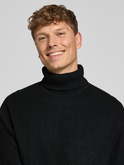 Männermodel trägt Strickpullover in Ripp-Optik mit Rollkragen von Lindbergh, schwarze Farbe, Nahaufnahme Oberkörper, Regular Fit, KI-modifiziertes Bild.