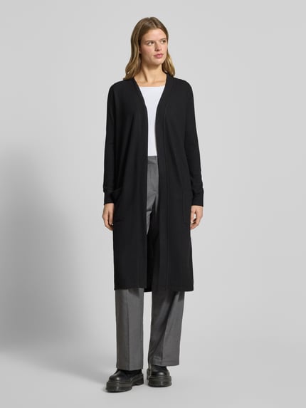 Frauenmodel trägt Longcardigan mit aufgesetzten Taschen Modell 'CITY' von Noisy May, schwarzer Material-Mix mit Stretch-Anteil, Regular-Fit, Rückenlänge 107 cm, Ärmellänge 63 cm, Ganzkörperansicht von vorne.