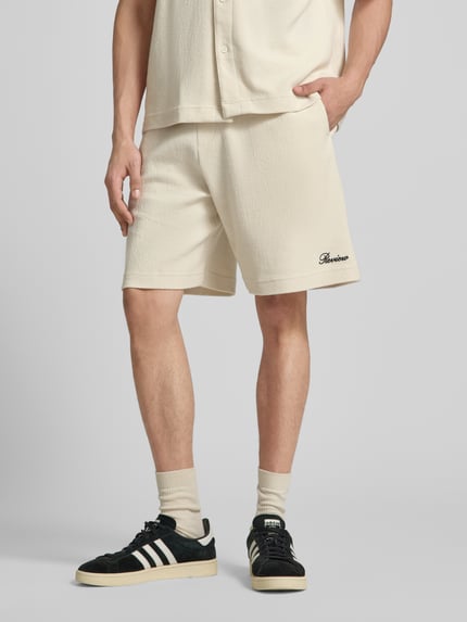 Männermodel trägt Shorts mit Label-Stitching von REVIEW aus Baumwoll-Mix, Regular-Fit, Strukturmuster, Nahaufnahme Oberschenkel.