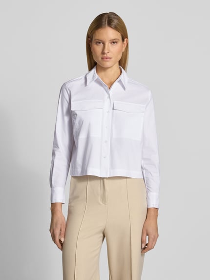 Frauenmodel trägt Regular Fit Hemdbluse mit Brusttaschen von More & More in Weiß, elastischer Baumwoll-Mix, ganzkörperansicht von vorne.