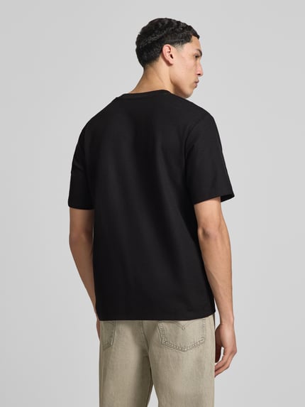Męski model nosi T-Shirt mit Stehkragen Modell 'AUSTIN' von Jack & Jones, elastyczna mieszanka materiałów z mieszanką bawełny, prosty krój, długość tyłu w rozmiarze m: 70 cm, czarny kolor, gładka tekstura, całkowity widok z tyłu