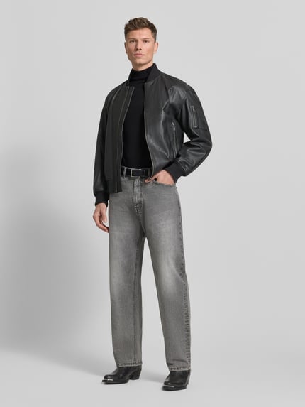 Männermodel trägt Rollkragenpullover aus Merinowolle Modell 'TRAY' von Selected Homme in Schwarz, körpernaher Schnitt, gerippte Abschlüsse, Ganzkörperansicht von vorne.