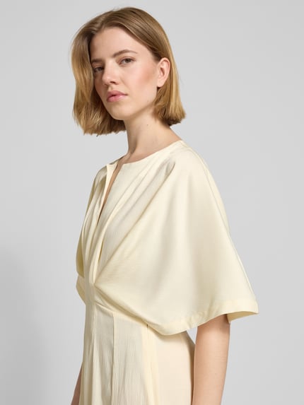 Frauenmodel trägt Midikleid mit V-Ausschnitt Modell 'VIANNA' von Copenhagen Muse, Taillierter Schnitt, Drapierungen, Nahaufnahme Oberkörper.
