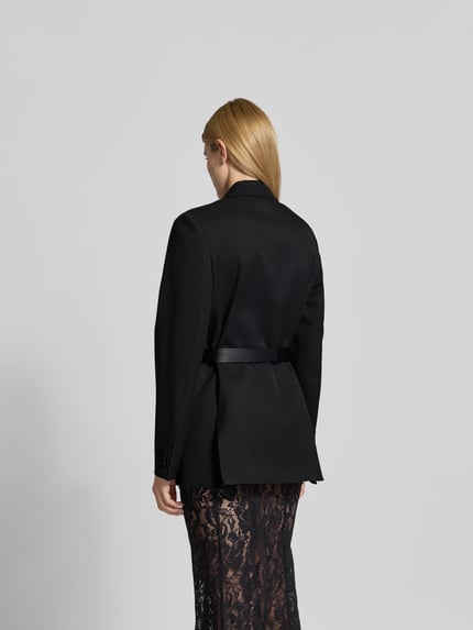Männermodel trägt Blazer mit Schurwoll-Anteil von Victoria Beckham, kolor czarny, materiał-mix, krój taliowany, taśma w talii, widok sylwetki od tyłu, Ganzkörperansicht Rückansicht.