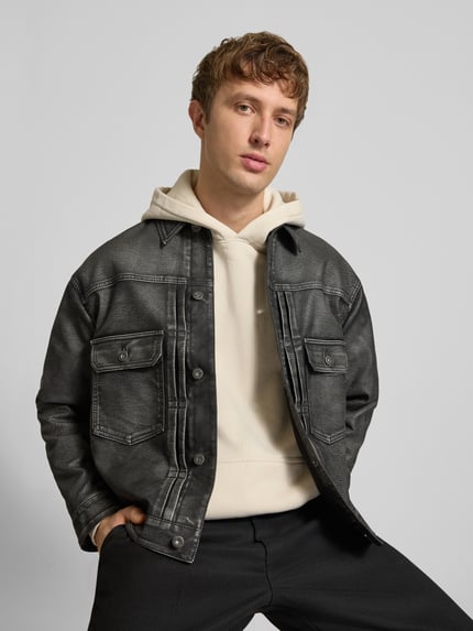 Męski model nosi Regular Fit Kunstlederjacke mit Label-Detail von HUGO, kurtka skórzana czarna, faktura matowa, Ganzkörperansicht von vorne, Herren Leder- / Kunstlederjacke von HUGO Blue.