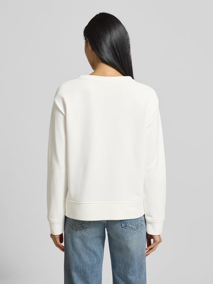 Modelka kobieca nosi Sweatshirt mit Motiv-Print und Rundhalsausschnitt od Milano Italy, kremowa biel, prosty krój, bawełniana mieszanka, widok całej sylwetki od tyłu.