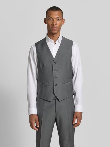 Männermodel trägt Regular Fit Weste aus reiner Schurwolle Modell 'Carlton' von CG - Club of Gents in Grau, V-Ausschnitt, Knopfleiste, Ganzkörperansicht von vorne. Rückenlänge bei Größe 50: 60 cm.