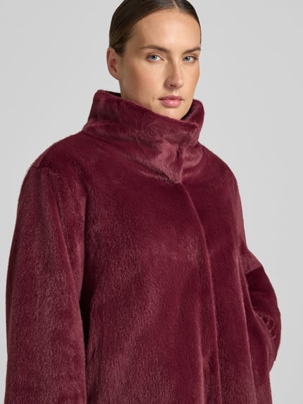 Frauenmodel trägt Jacke mit Stehkragen und gerippten Ärmelabschlüssen von White Label in Bordeaux, Nahaufnahme Oberkörper, gerader Schnitt, verdeckter Verschluss, Kontext: Rückenlänge 61 cm, Schulterbreite 43 cm, Brustweite 58 cm, Ärmellänge 61 cm.
