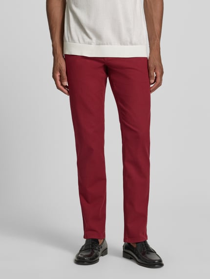 Mannenmodel draagt Slim Fit Jeans im 5-Pocket-Design van Christian Berg Men in bordeaux, katoenmix, knoop- en ritssluiting, slim fit, 5-pocketmodel, bandwijdte 42 cm, binnenbeenlengte 82 cm, vooraanzicht volledige lichaamsfoto.