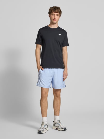 Männermodel trägt Shorts mit Label-Stitching und elastischem Bund von Nike in Hellblau, Regular-Fit, Ganzkörperansicht von vorne. Herren Shorts mit Tunnelzug, Bundweite bei Größe M 41 cm, Innenbeinlänge 14 cm.