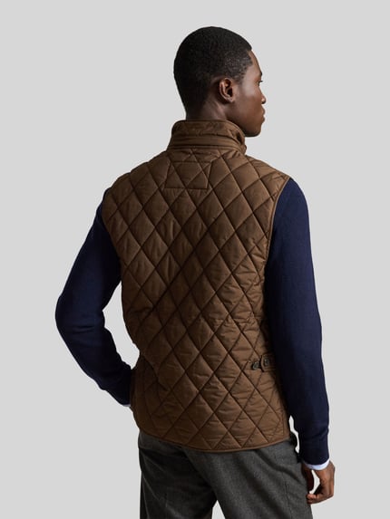 Männermodel trägt braune, gesteppte kamizelka Regular Fit Weste mit Logo-Patch Modell 'BEATON' von Polo Ralph Lauren, Ganzkörperansicht Rückansicht